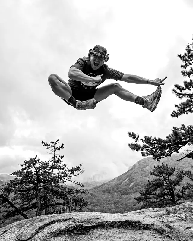 Mid-air jump on a mountain ledge